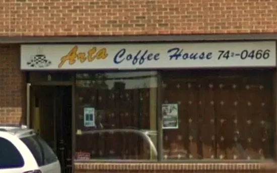The Arta Coffee House storefront on McArthur Avenue: brick wall, hand-lettered sign above a large window and a door